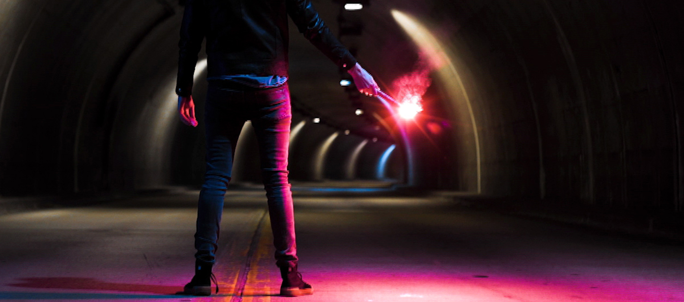 Person holding a flare in a dark tunnel